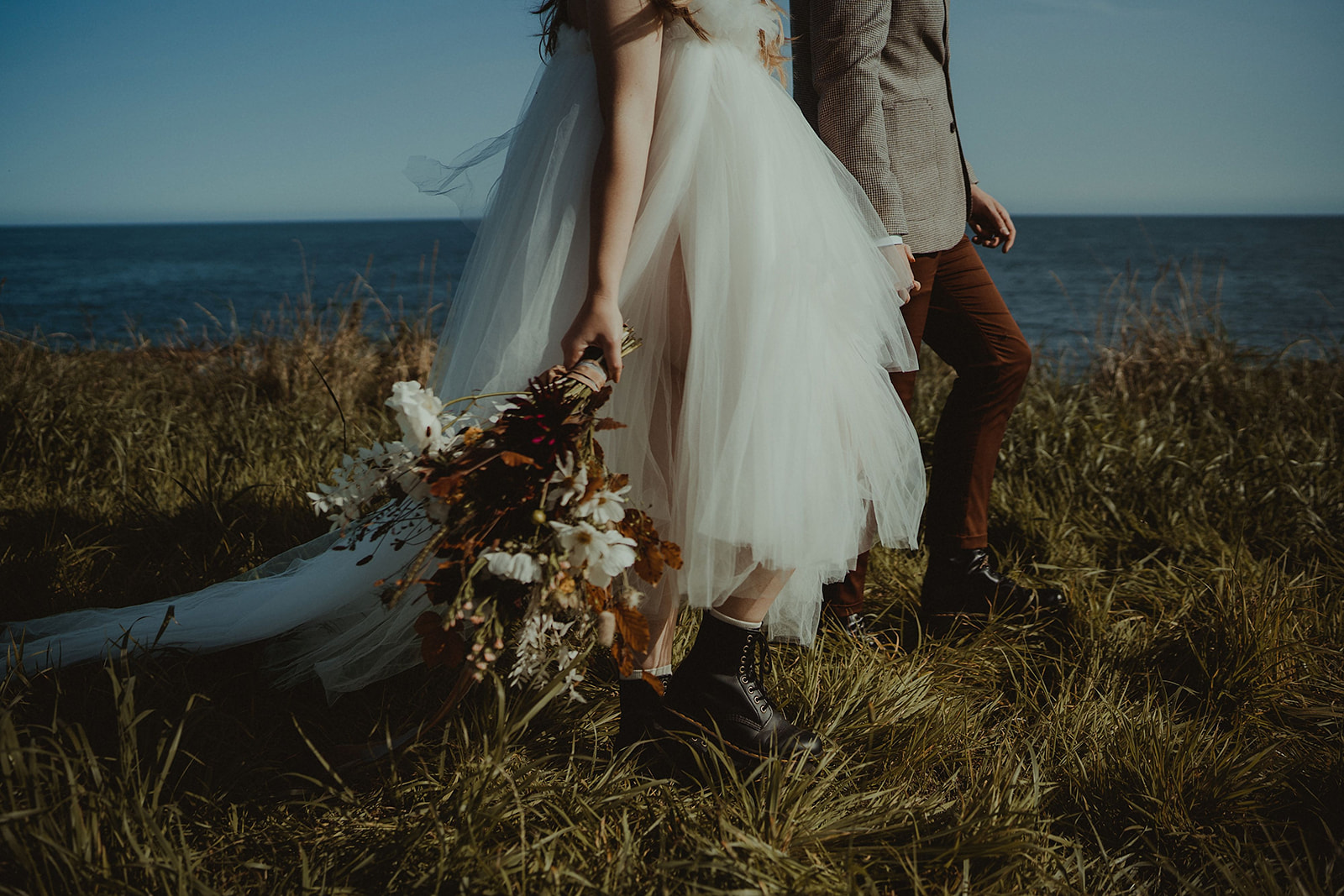 Elopement clifftop walk with tulle dress and wild autumnal wedding bouquet