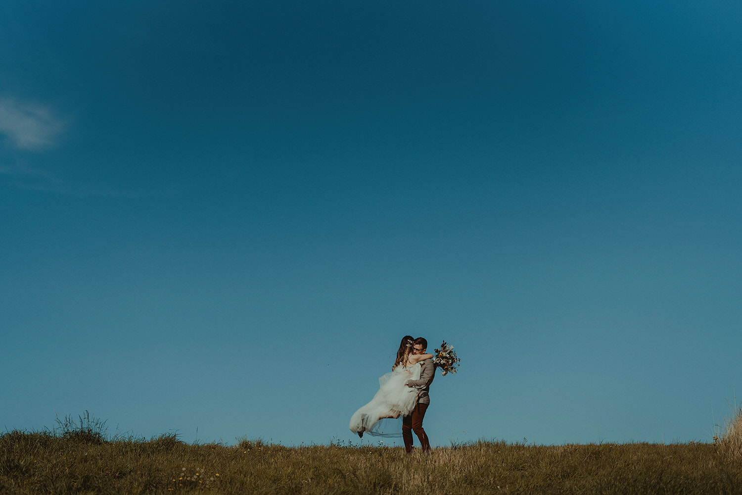 Elopement clifftop walk with tulle dress and wild autumnal wedding bouquet